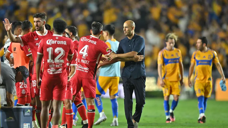 Cầu thủ Tigres UANL chạy nhanh với bóng trước sự áp đảo của hậu vệ Toluca Cầu thủ Tigres UANL chạy nhanh với bóng trước sự áp đảo của hậu vệ Toluca