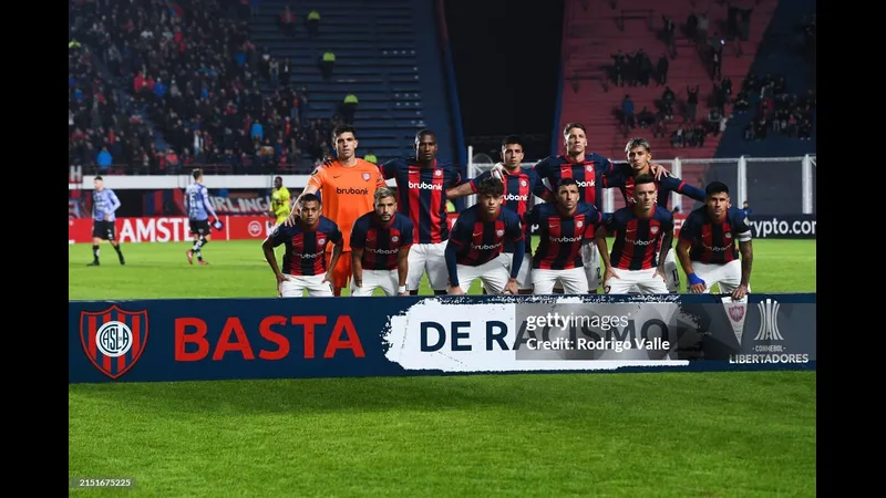 Cầu thủ San Lorenzo dẫn bóng trước sự truy đuổi của Sportivo Trinidense Cầu thủ San Lorenzo dẫn bóng trước sự truy đuổi của Sportivo Trinidense